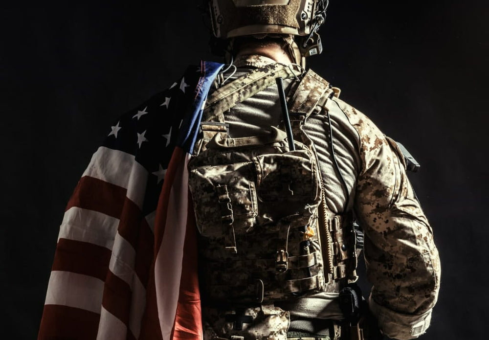 Veteran standing with an American flag, representing military appreciation and service discounts from Wehle Good Heating and Cooling LLC.